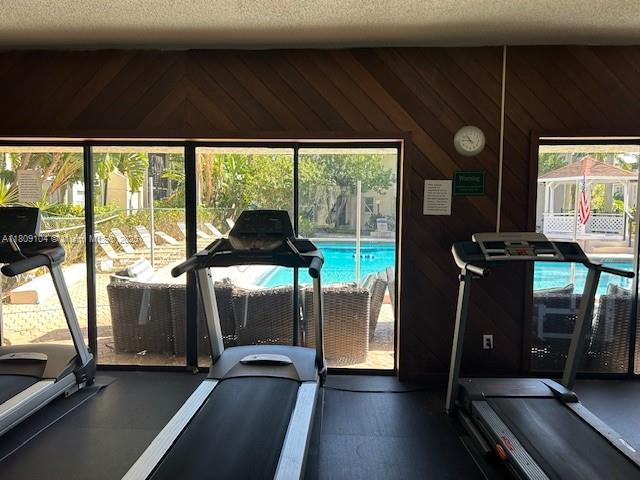 5326 NE 6th Ave Unit E23, Oakland Park, FL 33334 - gym with wood walls and a textured ceiling
