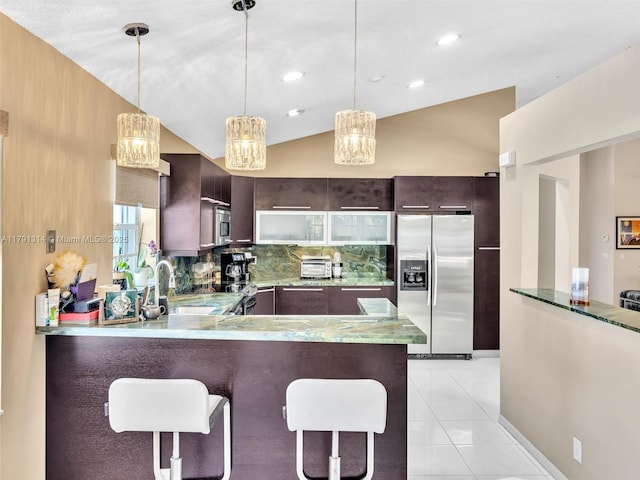 457 Cambridge Dr, Weston, FL 33326 - kitchen featuring stainless steel refrigerator with ice dispenser, dark brown cabinets, a peninsula, lofted ceiling, and tasteful backsplash