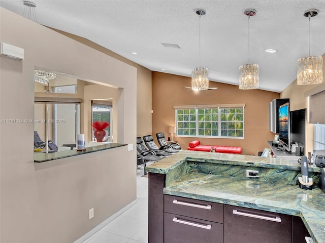 457 Cambridge Dr, Weston, FL 33326 - kitchen featuring light tile patterned floors, dark brown cabinets, pendant lighting, open floor plan, and light stone counters