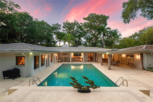 5465 Banyan Trl, Coral Gables, FL 33156 - pool at dusk featuring an outdoor pool and a patio