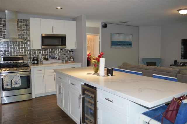 2220 NW 137th Ave, Sunrise, FL 33323 - kitchen featuring appliances with stainless steel finishes, wall chimney range hood, wine cooler, open floor plan, and a kitchen island