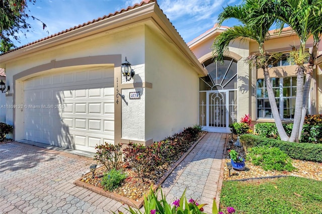 11564 Puerto Blvd, Boynton Beach, FL 33437 - entrance to property with stucco siding, a tile roof, a garage, and decorative driveway