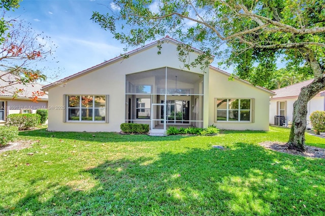11564 Puerto Blvd, Boynton Beach, FL 33437 - rear view of property with stucco siding, a sunroom, a yard, and central AC