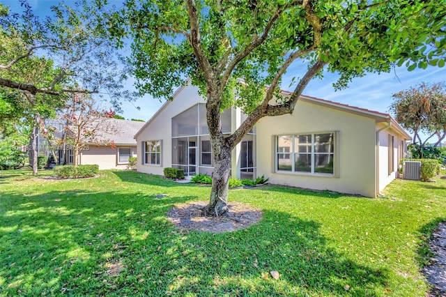 11564 Puerto Blvd, Boynton Beach, FL 33437 - rear view of house with a sunroom, central air condition unit, stucco siding, and a yard