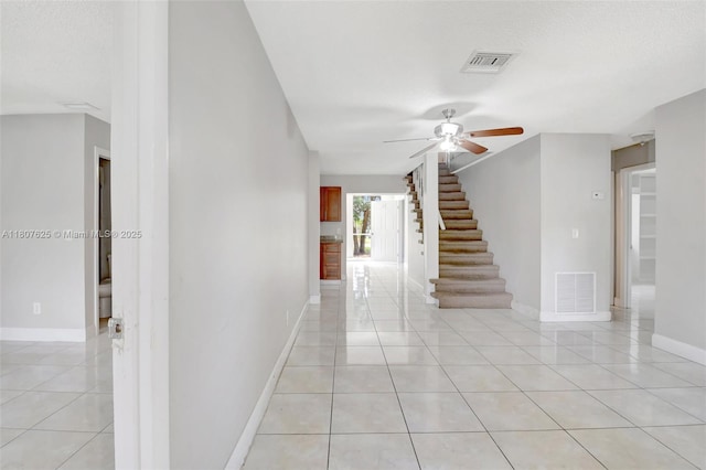 6160 Camp Lee Rd, West Palm Beach, FL 33417 - hallway featuring light tile patterned floors, stairs, and baseboards