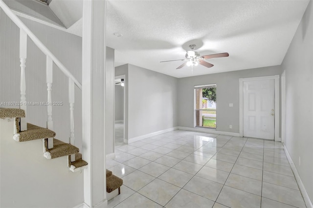 6160 Camp Lee Rd, West Palm Beach, FL 33417 - empty room featuring stairs, a ceiling fan, light tile patterned flooring, a textured ceiling, and baseboards