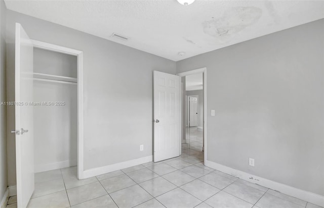 6160 Camp Lee Rd, West Palm Beach, FL 33417 - unfurnished bedroom featuring a closet, light tile patterned flooring, baseboards, and a textured ceiling