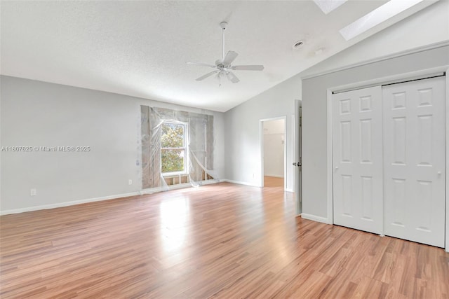 6160 Camp Lee Rd, West Palm Beach, FL 33417 - unfurnished living room with lofted ceiling, a ceiling fan, a skylight, light wood-style floors, and baseboards