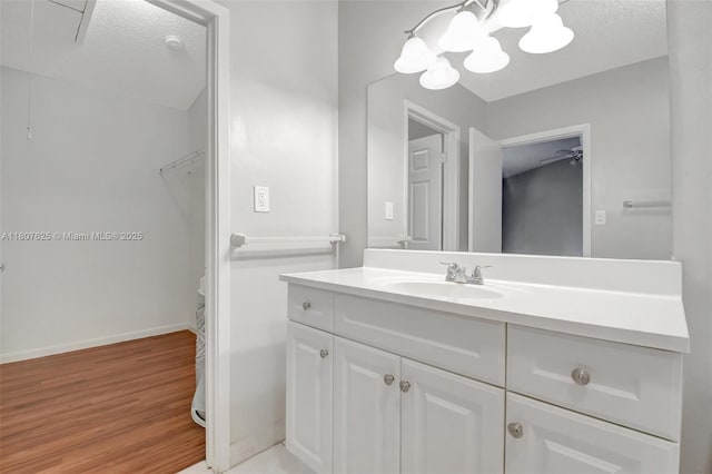 6160 Camp Lee Rd, West Palm Beach, FL 33417 - bathroom featuring vanity, wood finished floors, a spacious closet, a chandelier, and baseboards