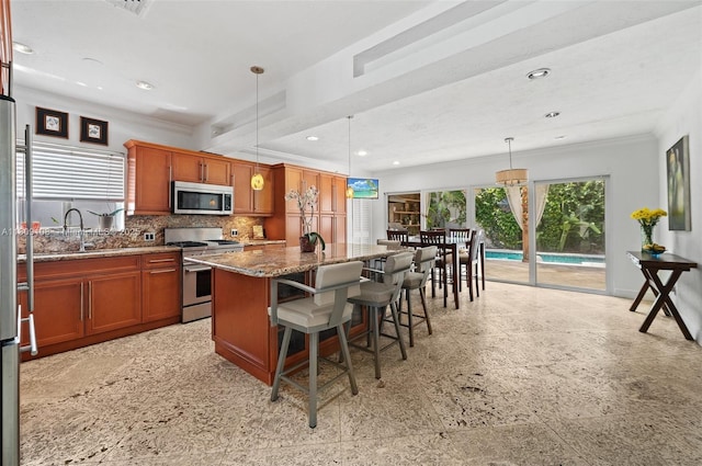 1771 Wa Kee Na Dr, Miami, FL 33133 - kitchen with stainless steel appliances, a center island, tasteful backsplash, crown molding, and stone countertops