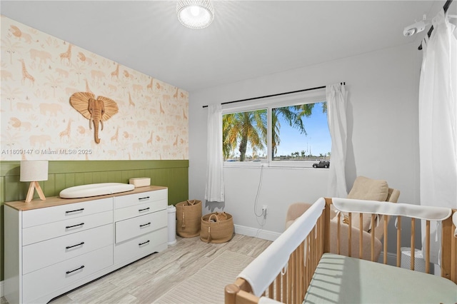 8930 SW 50th Ter, Miami, FL 33165 - bedroom with wallpapered walls, wainscoting, light wood-style flooring, baseboards, and a crib