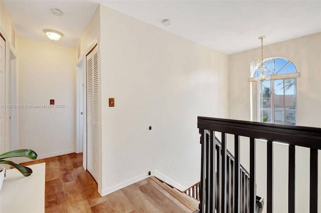 5972 SW 163rd Pl, Miami, FL 33193 - hall featuring an upstairs landing, light wood-style floors, a chandelier, and baseboards