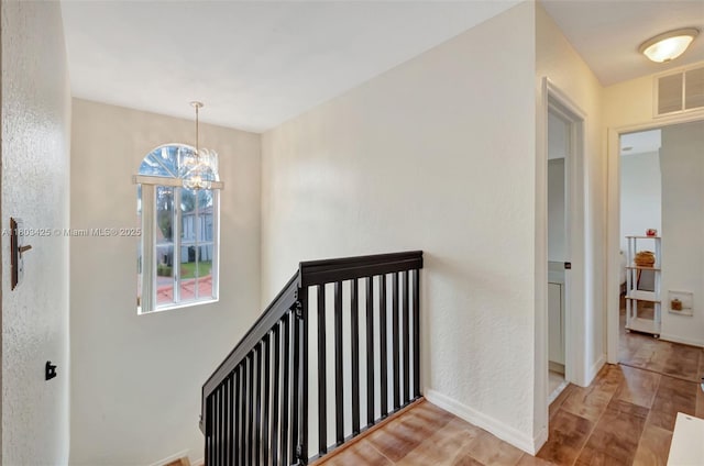 5972 SW 163rd Pl, Miami, FL 33193 - hallway featuring wood finished floors, a chandelier, and baseboards