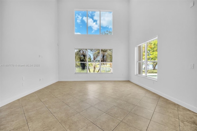 5466 SW 187th Ter, Miramar, FL 33029 - spare room featuring light tile patterned flooring, a towering ceiling, and baseboards