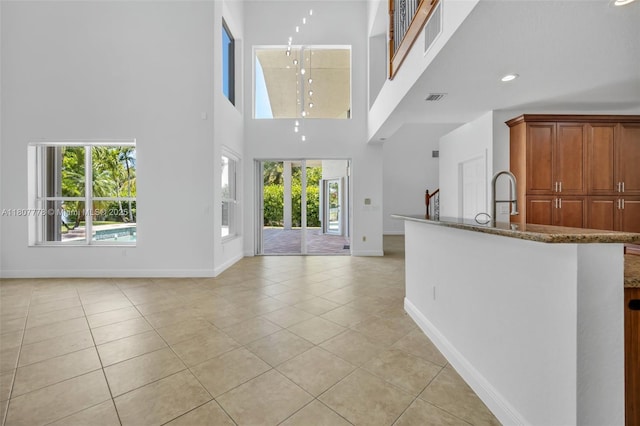 5466 SW 187th Ter, Miramar, FL 33029 - unfurnished living room with baseboards, a towering ceiling, light tile patterned floors, and recessed lighting