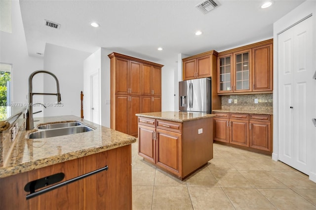 5466 SW 187th Ter, Miramar, FL 33029 - kitchen with stainless steel refrigerator with ice dispenser, a sink, a kitchen island, brown cabinetry, and tasteful backsplash