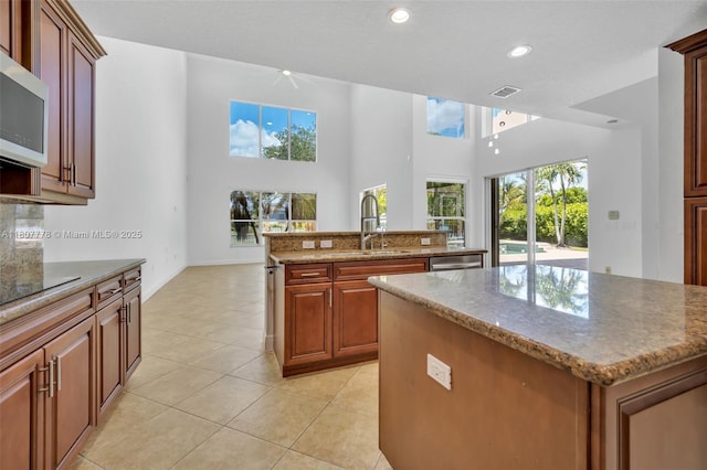 5466 SW 187th Ter, Miramar, FL 33029 - kitchen with a kitchen island with sink, stainless steel appliances, light tile patterned floors, stone countertops, and recessed lighting