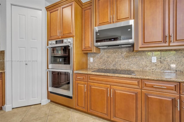 5466 SW 187th Ter, Miramar, FL 33029 - kitchen featuring stainless steel appliances, tasteful backsplash, brown cabinets, and light tile patterned flooring