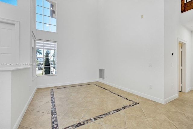 5466 SW 187th Ter, Miramar, FL 33029 - tiled empty room featuring a high ceiling, baseboards, and inlaid floor details
