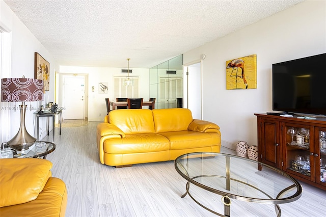 2000 S Ocean Blvd Unit 3B, Lauderdale By The Sea, FL 33062 - living area featuring a textured ceiling and light wood-type flooring