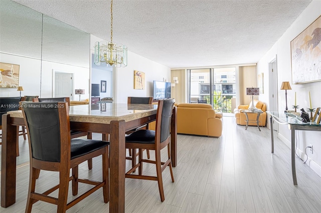 2000 S Ocean Blvd Unit 3B, Lauderdale By The Sea, FL 33062 - dining room featuring a chandelier, a textured ceiling, and light wood-style floors