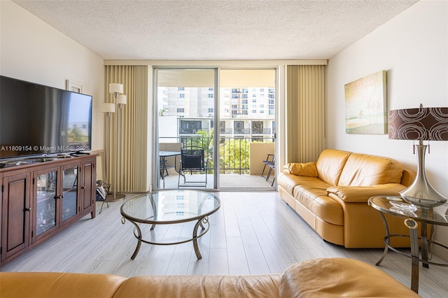 2000 S Ocean Blvd Unit 3B, Lauderdale By The Sea, FL 33062 - living room featuring a wall of windows, wood finished floors, and a textured ceiling