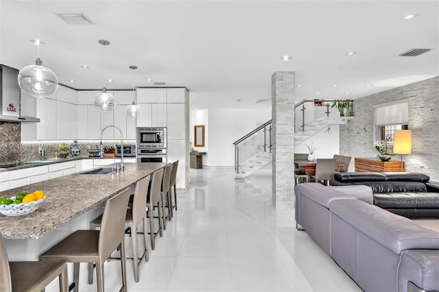 4362 NW 112th Ct, Doral, FL 33178 - kitchen featuring modern cabinets, stainless steel appliances, open floor plan, white cabinetry, and light tile patterned floors