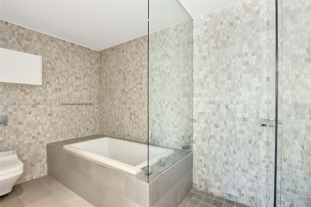 68 SE 6th St Unit 1203, Miami, FL 33131 - full bathroom with tile walls, toilet, and a garden tub