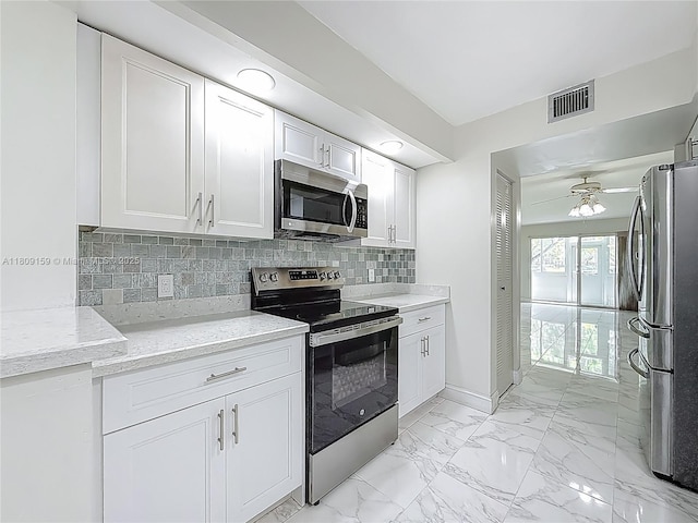 1100 SW 130th Ave Unit 111H, Pembroke Pines, FL 33027 - kitchen with appliances with stainless steel finishes, light marble finish flooring, white cabinetry, tasteful backsplash, and light stone countertops