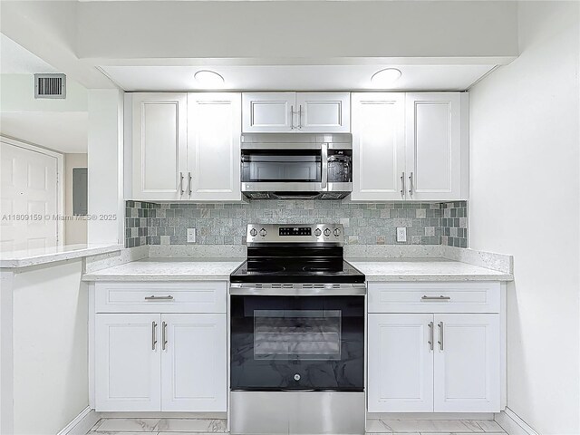 1100 SW 130th Ave Unit 111H, Pembroke Pines, FL 33027 - kitchen featuring appliances with stainless steel finishes, baseboards, light marble finish floors, and white cabinets