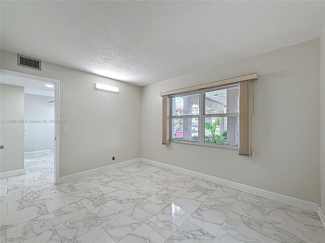 1100 SW 130th Ave Unit 111H, Pembroke Pines, FL 33027 - spare room with light marble finish floors, baseboards, and a textured ceiling