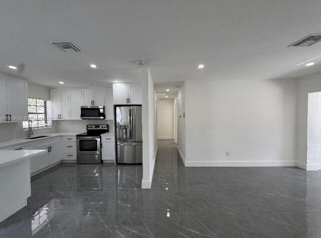12455 SW 187th Ter, Miami, FL 33177 - kitchen featuring appliances with stainless steel finishes, a sink, recessed lighting, white cabinets, and baseboards