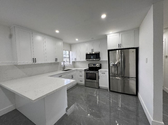 12455 SW 187th Ter, Miami, FL 33177 - kitchen with stainless steel appliances, baseboards, white cabinetry, a peninsula, and a sink