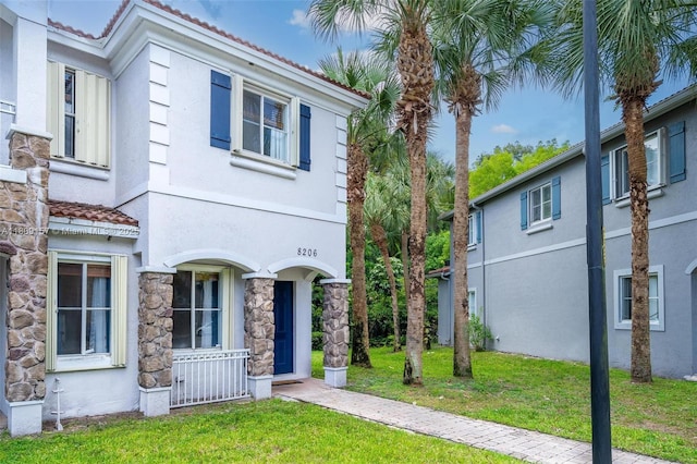 8206 SW 29th St Unit 104, Miramar, FL 33025 - view of front of property with a tiled roof, a front lawn, stone siding, and stucco siding