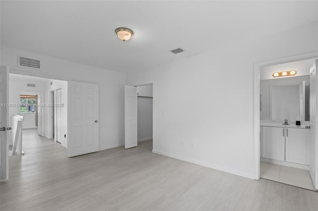 8206 SW 29th St Unit 104, Miramar, FL 33025 - unfurnished bedroom with light wood finished floors, baseboards, and ensuite bathroom