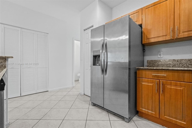 8206 SW 29th St Unit 104, Miramar, FL 33025 - kitchen with stainless steel fridge with ice dispenser, brown cabinets, stone countertops, and light tile patterned floors