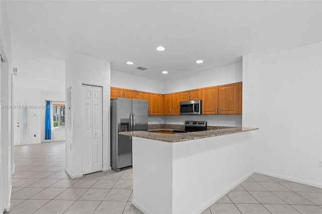 8206 SW 29th St Unit 104, Miramar, FL 33025 - kitchen with appliances with stainless steel finishes, recessed lighting, a peninsula, light tile patterned floors, and brown cabinetry