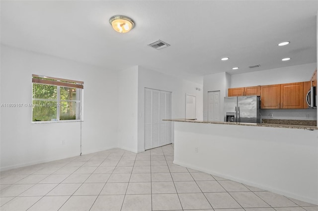8206 SW 29th St Unit 104, Miramar, FL 33025 - kitchen with appliances with stainless steel finishes, brown cabinets, recessed lighting, a peninsula, and stone countertops