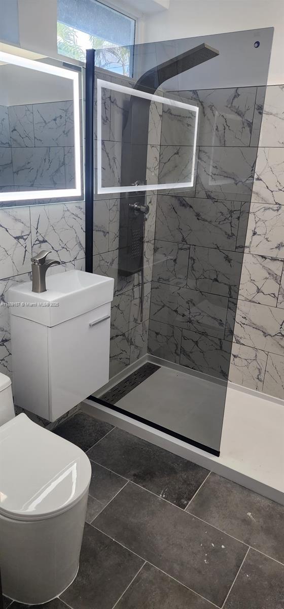 5812 NW 20th Ct, Margate, FL 33063 - bathroom with toilet, a marble finish shower, and tile walls