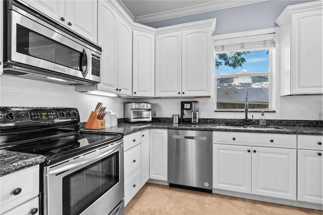 849 SW 11th Ct, Fort Lauderdale, FL 33315 - kitchen with stainless steel appliances, a sink, ornamental molding, white cabinetry, and backsplash