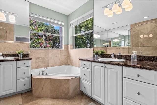 849 SW 11th Ct, Fort Lauderdale, FL 33315 - bathroom featuring two vanities, a bath, tile walls, tile patterned floors, and a shower with door