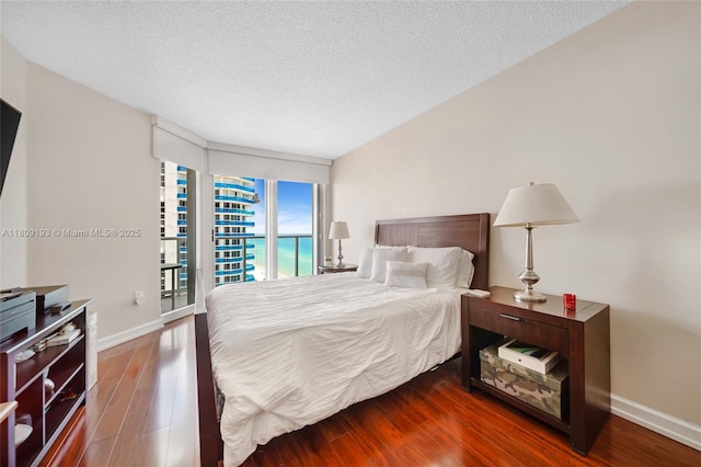 16445 Collins Ave Unit 2226, Sunny Isles Beach, FL 33160 - bedroom featuring baseboards, wood finished floors, a textured ceiling, and access to outside