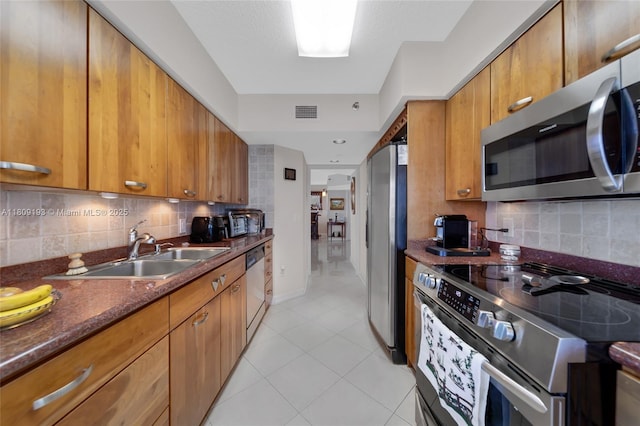 16445 Collins Ave Unit 2226, Sunny Isles Beach, FL 33160 - kitchen with stainless steel appliances, a sink, brown cabinets, and light tile patterned flooring