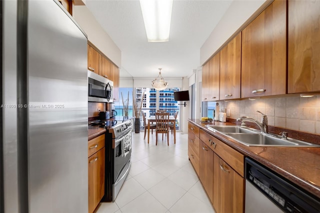 16445 Collins Ave Unit 2226, Sunny Isles Beach, FL 33160 - kitchen featuring appliances with stainless steel finishes, a sink, dark countertops, and brown cabinetry