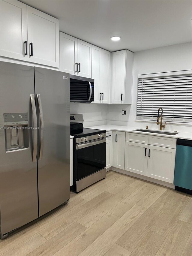9201 Sunrise Lakes Blvd Unit 301, Sunrise, FL 33322 - kitchen featuring appliances with stainless steel finishes, a sink, light wood-type flooring, white cabinetry, and light countertops