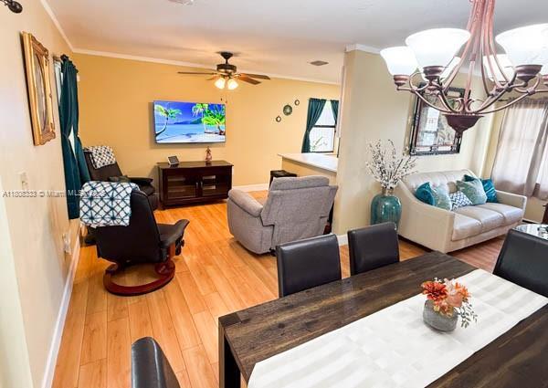 11321 SW 162nd Ter, Miami, FL 33157 - living room with ornamental molding, baseboards, light wood finished floors, a chandelier, and ceiling fan