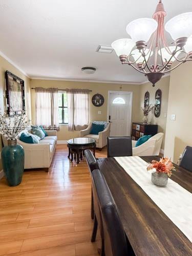 11321 SW 162nd Ter, Miami, FL 33157 - dining room with ornamental molding, a chandelier, light wood finished floors, and baseboards