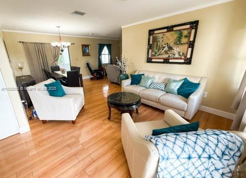 11321 SW 162nd Ter, Miami, FL 33157 - living area with ornamental molding, light wood-style floors, a chandelier, and baseboards