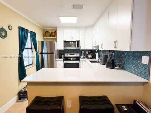 11321 SW 162nd Ter, Miami, FL 33157 - kitchen with stainless steel appliances, decorative backsplash, light countertops, a sink, and crown molding