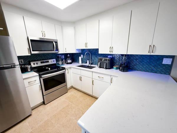 11321 SW 162nd Ter, Miami, FL 33157 - kitchen featuring appliances with stainless steel finishes, a sink, and light countertops